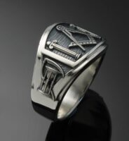 A silver ring with a masonic symbol on it.