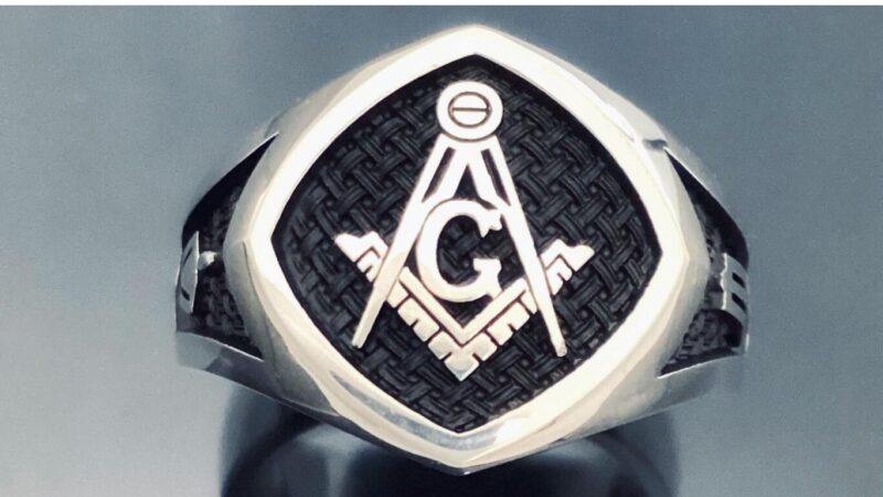 A silver ring with a masonic symbol on it.