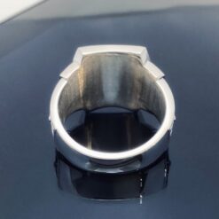A silver ring sitting on top of a black surface.